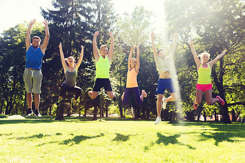 fitness, sport, friendship and healthy lifestyle concept - group of happy teenage friends or sportsmen jumping high outdoors