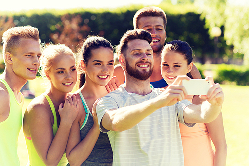 fitness, sport, friendship, technology and healthy lifestyle concept - group of happy teenage friends or sportsmen taking selfie with smartphone outdoors