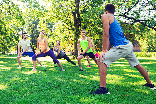 fitness, sport, friendship and healthy lifestyle concept - group of happy teenage friends or sportsmen exercising and doing lunge at boot camp