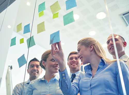 business, people, teamwork and planning concept - smiling business team with marker and stickers working in office