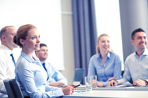 business, people and teamwork concept - group of smiling businesspeople meeting on presentation in office