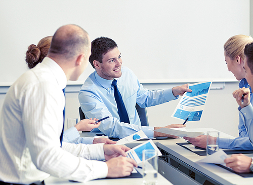 business, people and teamwork concept - smiling business team with papers meeting in office