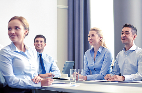 business, people and teamwork concept - group of smiling businesspeople meeting on presentation in office