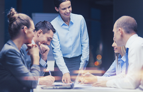 business, technology and office concept - smiling female boss talking to business team