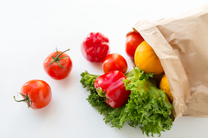 cooking, , vegetarian food and healthy eating concept - close up of paper bag with fresh ripe juicy vegetables and greens on kitchen table at home