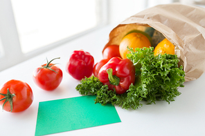 cooking, diet, vegetarian food and healthy eating concept - close up of paper bag with fresh ripe juicy vegetables and greens on kitchen table at home