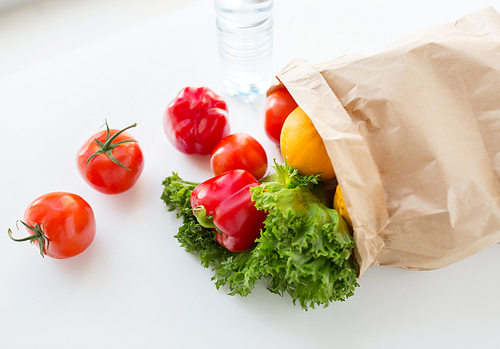 cooking, , vegetarian food and healthy eating concept - close up of paper bag with fresh ripe juicy vegetables and greens on kitchen table at home
