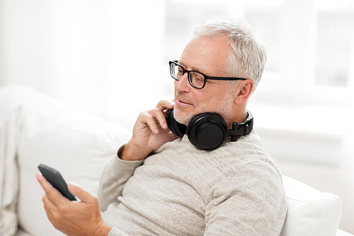 technology, people, lifestyle and distance learning concept - happy senior man with smartphone and headphones at home