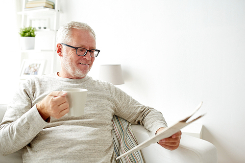 leisure, information, people and mass media concept - happy smiling senior man in glasses reading newspaper at home