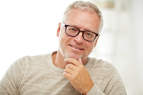 old age, vision and people concept - close up of smiling senior man in glasses thinking