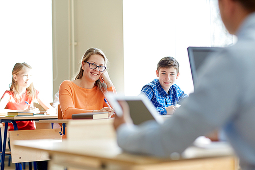 education, learning and people concept - group of students with books writing school test