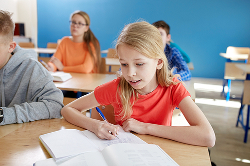 education, learning and people concept - student girl with book writing school test