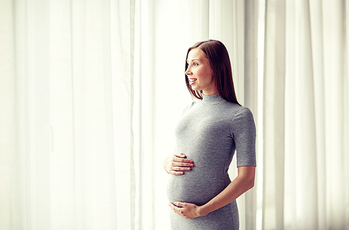 pregnancy, motherhood, people and expectation concept - happy pregnant woman with big tummy at home