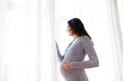 pregnancy, motherhood, people and expectation concept - close up of happy pregnant woman with big belly looking to window