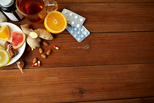 healthcare and ethnoscience concept - traditional medicine and drug pills on wooden table