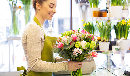 people, business, sale and floristry concept - close up of happy florist woman making bunch at flower shop