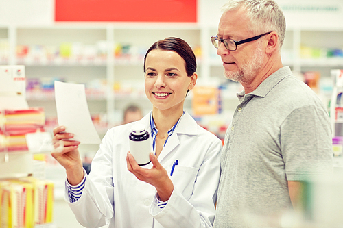 medicine, pharmaceutics, health care and people concept - happy pharmacist and senior man customer with drug and prescription at drugstore