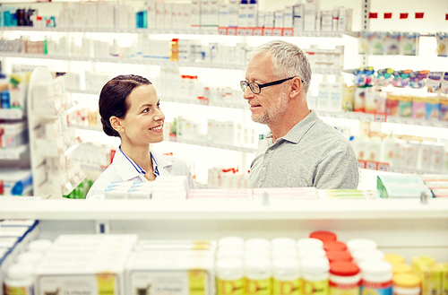medicine, pharmaceutics, health care and people concept - happy pharmacist talking to senior man customer at drugstore