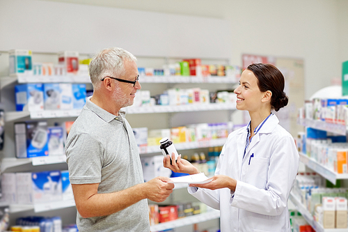 medicine, pharmaceutics, health care and people concept - happy pharmacist giving drug to senior man customer and taking prescription at drugstore