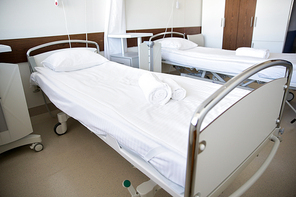 healthcare, medicine and ambulatory concept - hospital ward with clean empty beds
