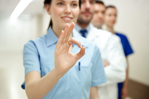 healthcare, gesture, people and medicine concept - close up of happy doctors at hospital showing ok hand sign