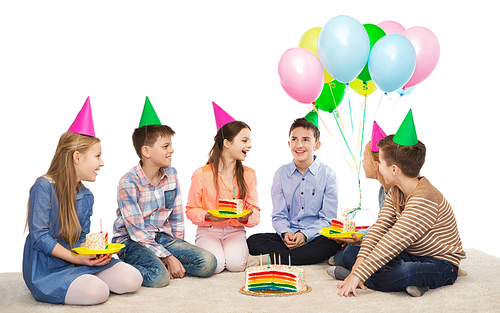 childhood, holidays, celebration, friendship and people concept - happy smiling children in party hats with birthday cake and balloons
