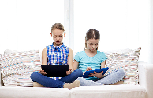 people, children, technology, friends and friendship concept - girls looking to tablet pc computers at home