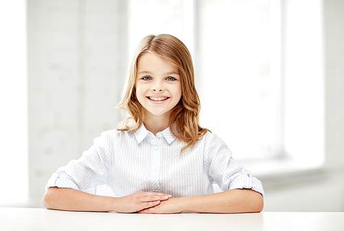 education, elementary school, learning, children and people concept - happy smiling girl sitting at table