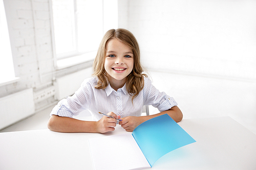 education, elementary school, learning and people concept - happy smiling girl with notebook and pen