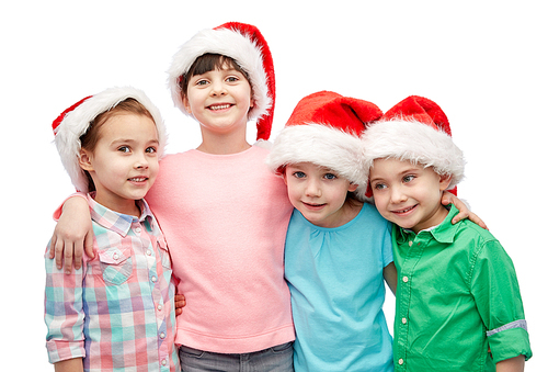 childhood, christmas, holidays, friendship and people concept - group of happy smiling little children in santa hats hugging