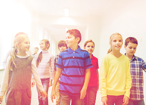 education, elementary school, drinks, children and people concept - group of smiling school kids walking in corridor