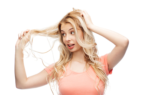 hair care, hairstyle and people concept - young woman or teenage girl holding strand of her hair