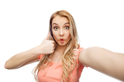 emotions, expressions and people concept - happy young woman taking selfie, making fish face and showing thumbs up