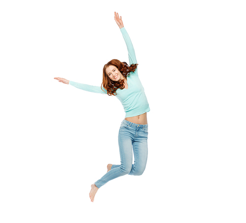 happiness, freedom, motion and people concept - smiling young woman jumping in air