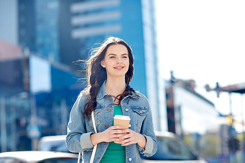 drinks and people concept - happy young woman or teenage girl drinking coffee from paper cup on city street