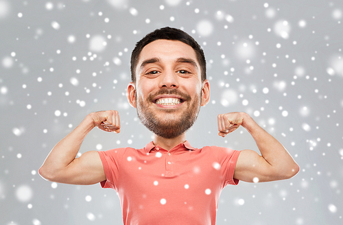 fitness, strength, sport, winter and people concept - happy smiling young man showing biceps power(funny cartoon style character with big head) over snow on gray background