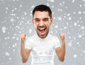 emotion, gesture, winter, christmas and people concept - angry young man celebrating victory and screaming (funny cartoon style character with big head) over snow on gray background