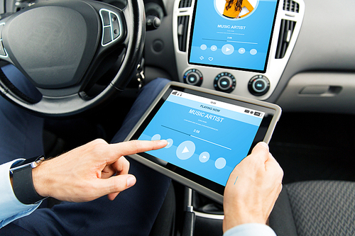 transport, business trip, technology and people concept - close up of male hands holding tablet pc computer with music player on screen in car