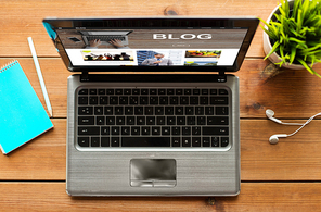 blogging, business and technology concept - close up of laptop computer with blog page on screen wooden table