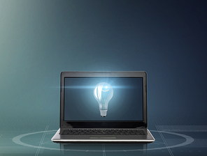 technology, idea and business concept - laptop computer with light bulb on screen over dark gray background