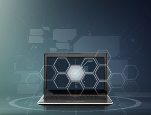 technology, virtual reality and network connection concept - laptop computer with hexagonal projection over dark gray background