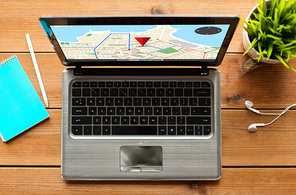 navigation, location, and technology concept - close up of laptop computer with gps navigator map on screen on wooden table