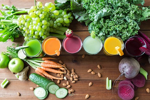 healthy eating, drinks, diet and detox concept - glasses with different fruit or vegetable juices and food on table