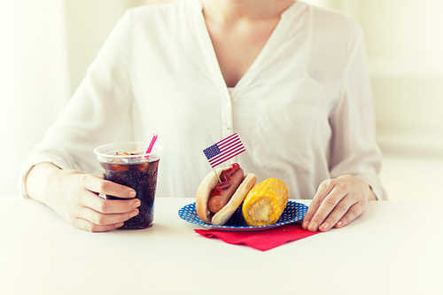 american 독립기념일, celebration, patriotism and holidays concept - close up of woman hands with hot dog and corn holding cola drink in plastic cup on 4th july party