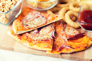 fast food, italian kitchen and eating concept - close up of pizza and other snacks on wooden table