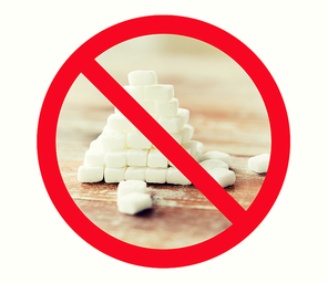 food, junk-food, diet and unhealthy eating concept - close up of white sugar pyramid on wooden table over red circle-backslash no sign
