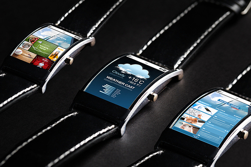 modern technology, object and media concept - close up of black smart watch set with weather cast and business news application