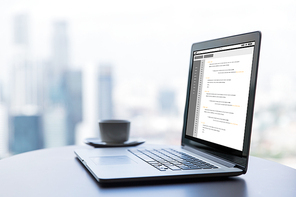 technology, programming, business and modern life concept- close up of open laptop computer with coding on screen and coffee cup on table at office or hotel room
