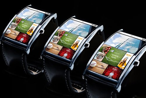 modern technology, object and media concept - close up of black smart watch set with news application on screen