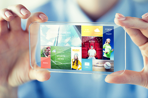 business, technology, media and people concept - close up of woman hand holding and showing transparent with internet applications on screen smartphone at office